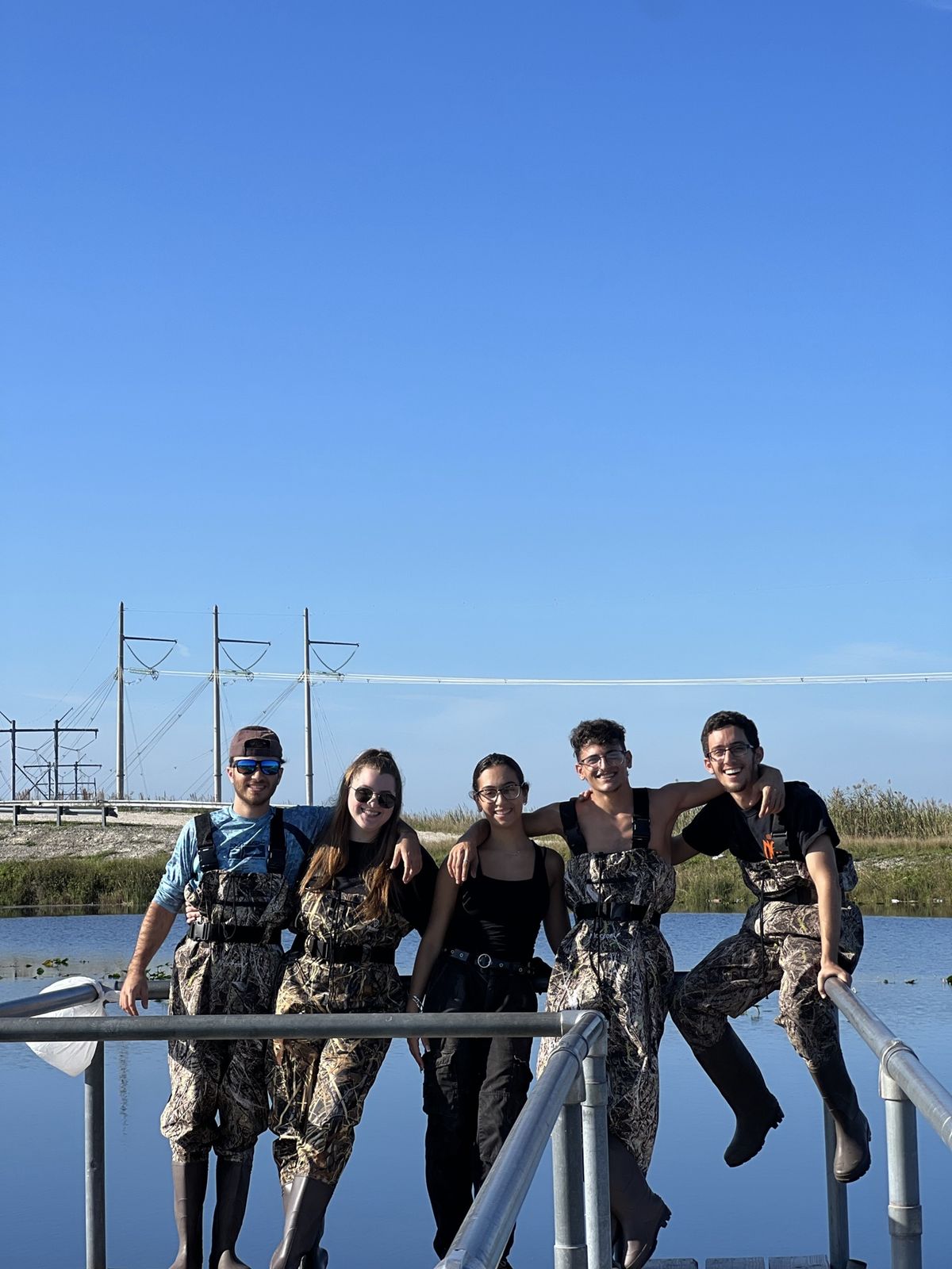 Five friends in waders posing on a dock