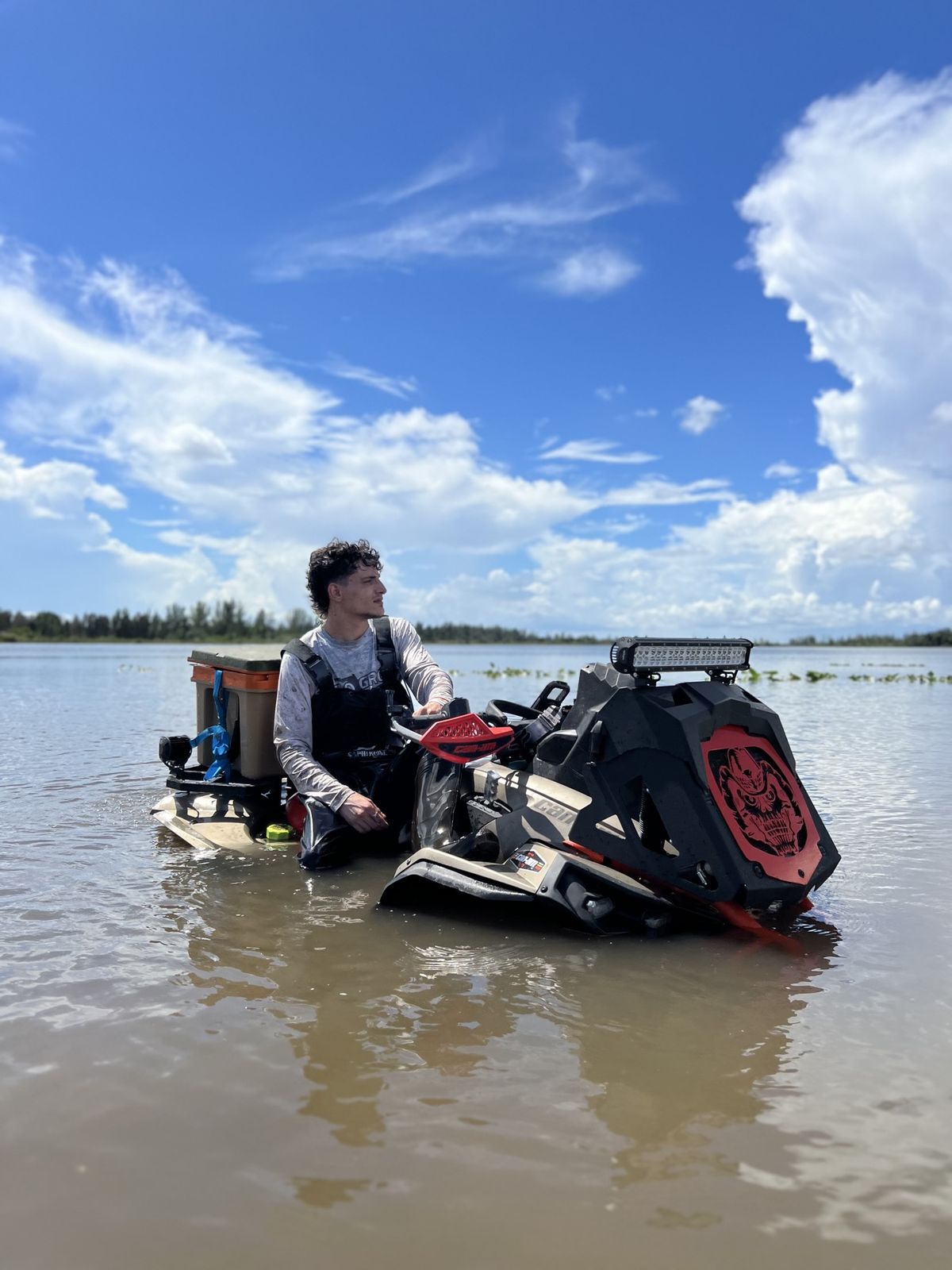 Rider on a muddy ATV in deep water