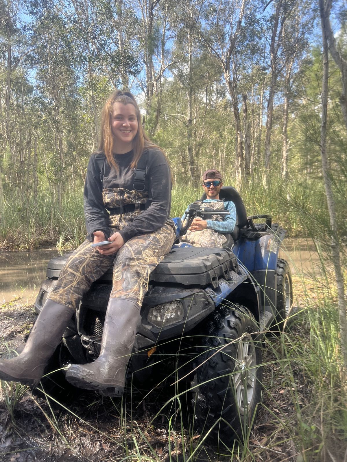 Woman sitting on an ATV in the woods