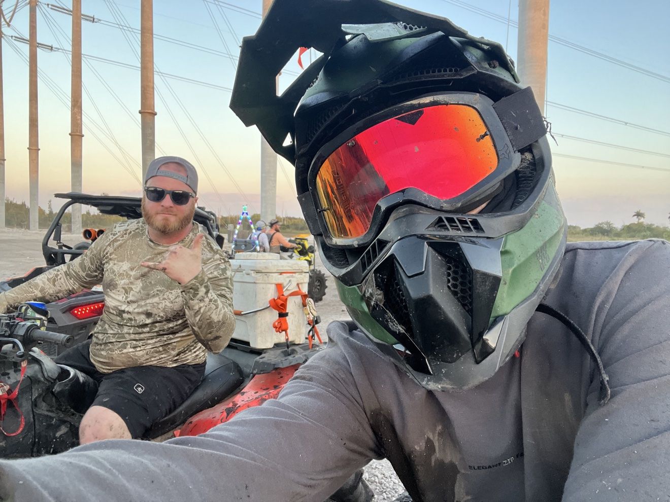 Helmet selfie of a rider with a friend on an ATV