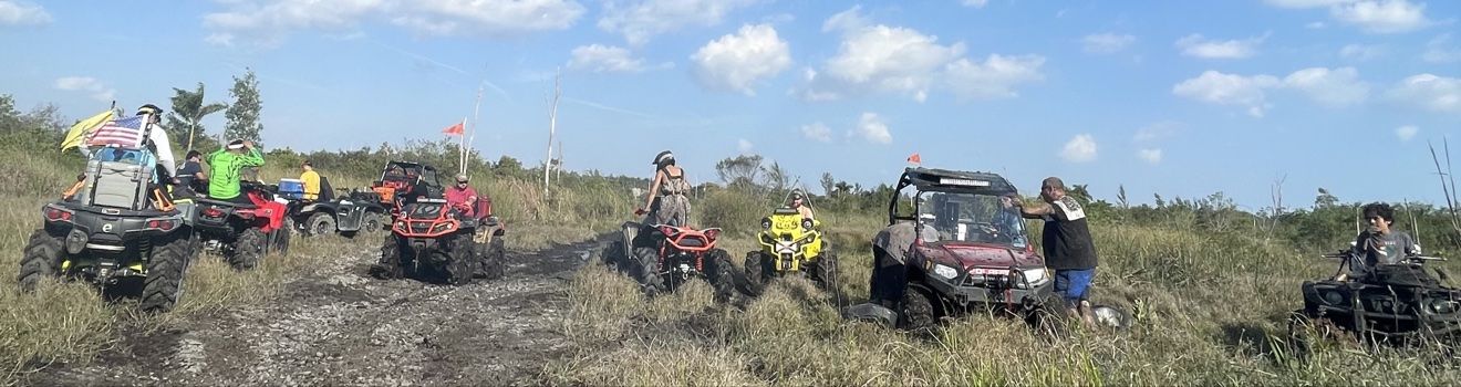 Staging area with ATVs and riders, panoramic view