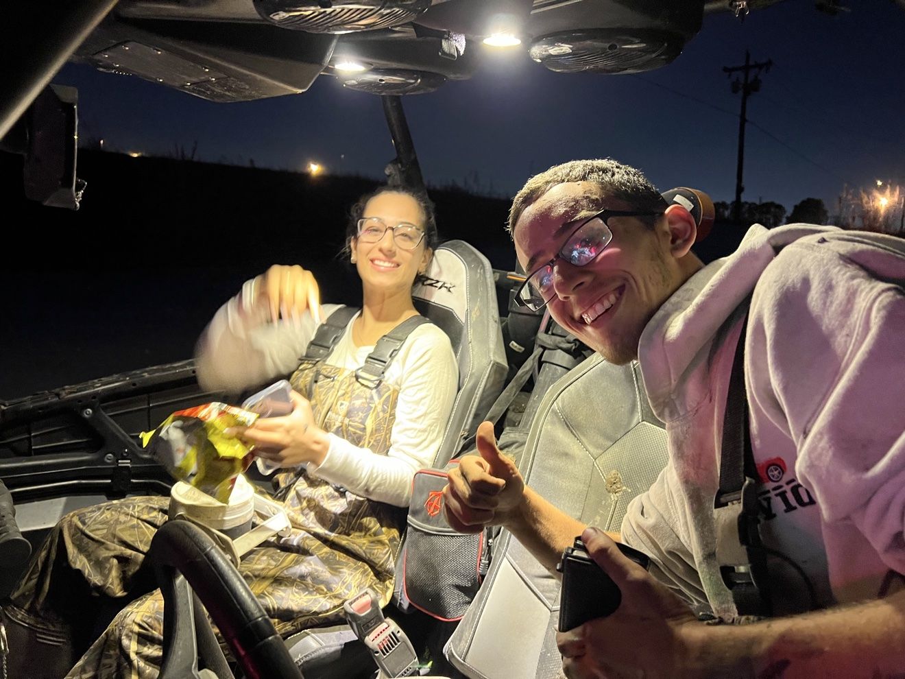 Couple smiling inside a SXS at night