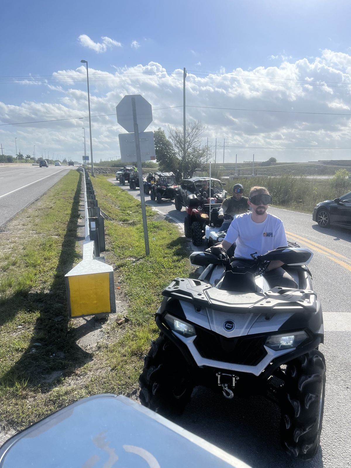 Convoy of ATVs riding on a paved road