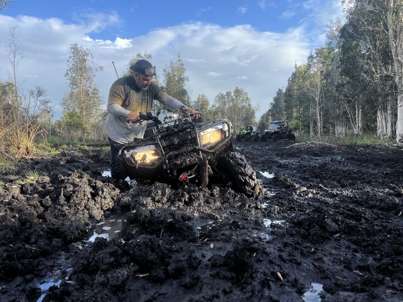 ATV climbing out of a deep mud pit