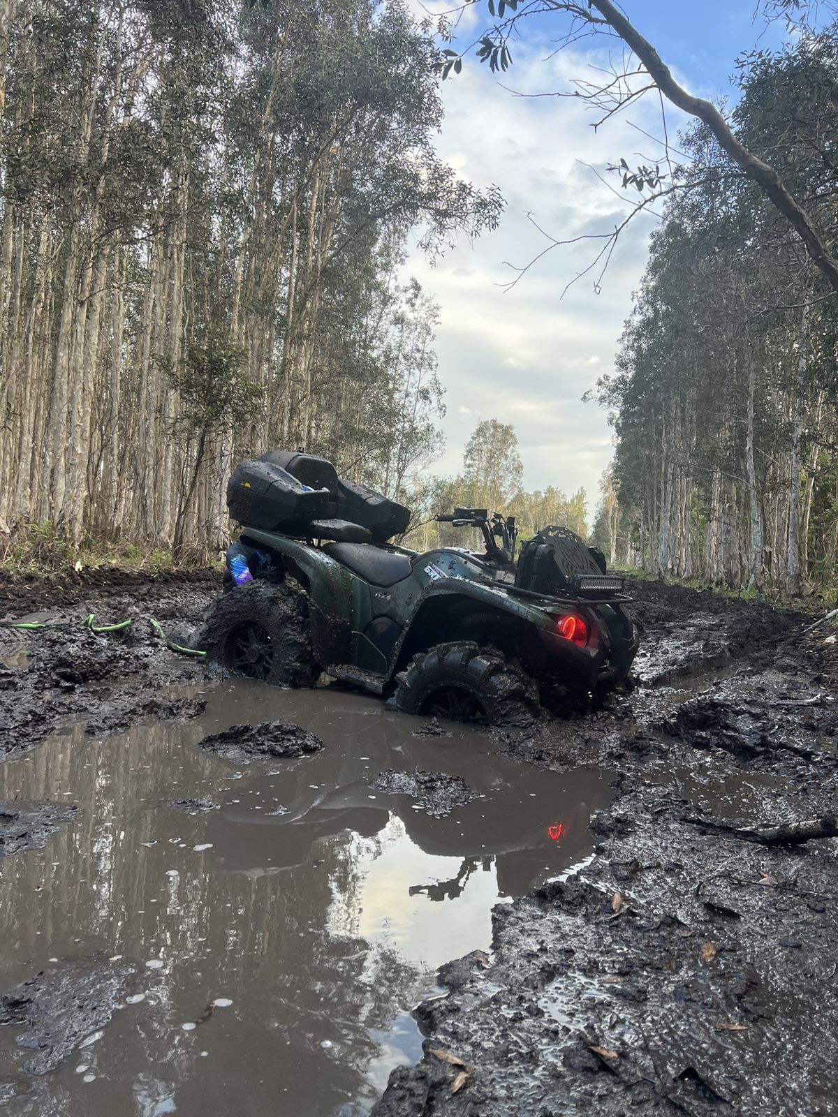 ATV deep in mud on a swamp trail