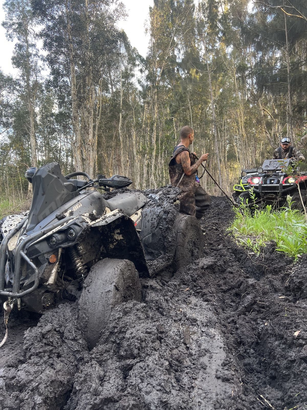 Two ATVs stuck in deep mud