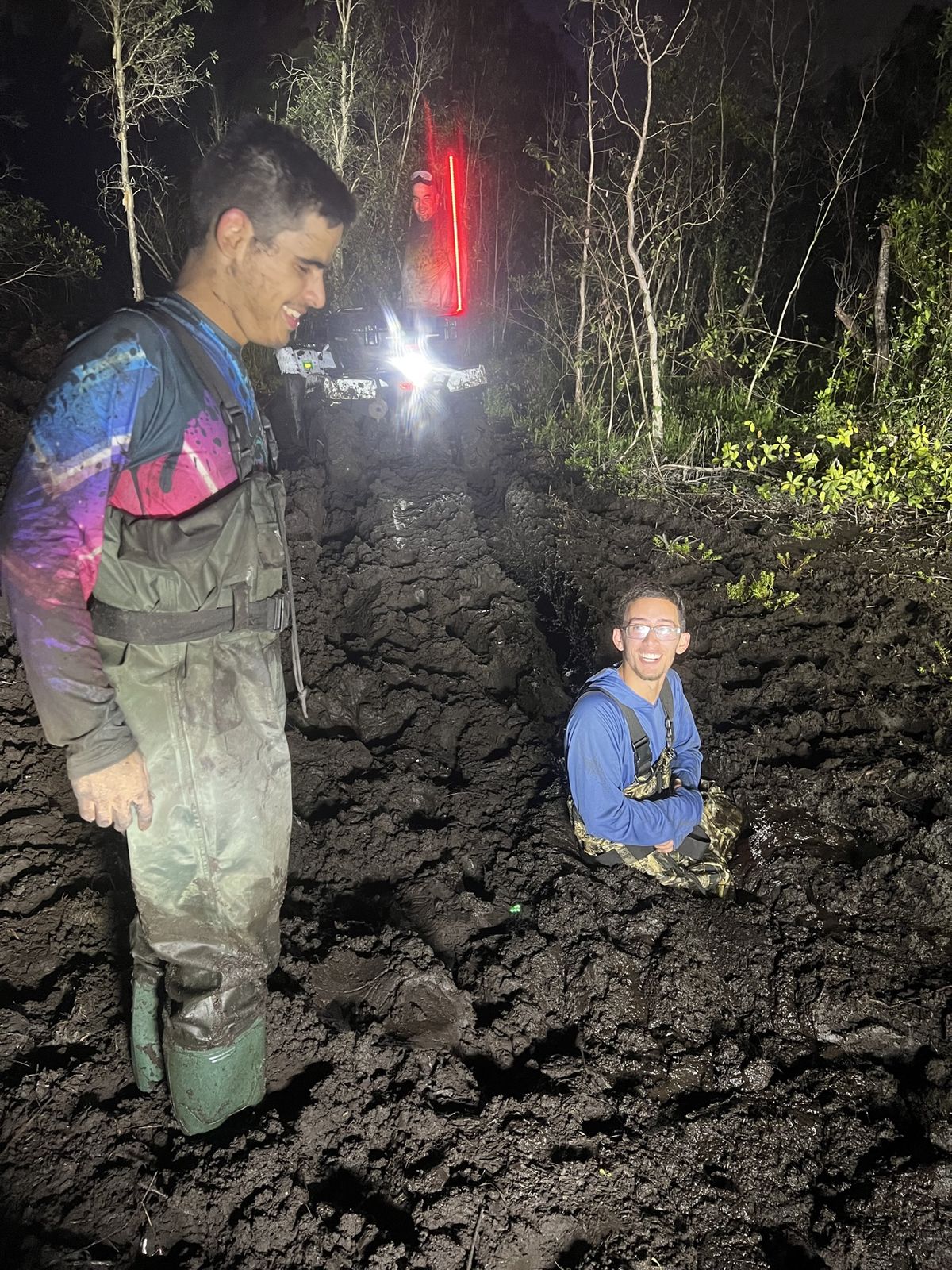 Rider and a kid in deep mud at night