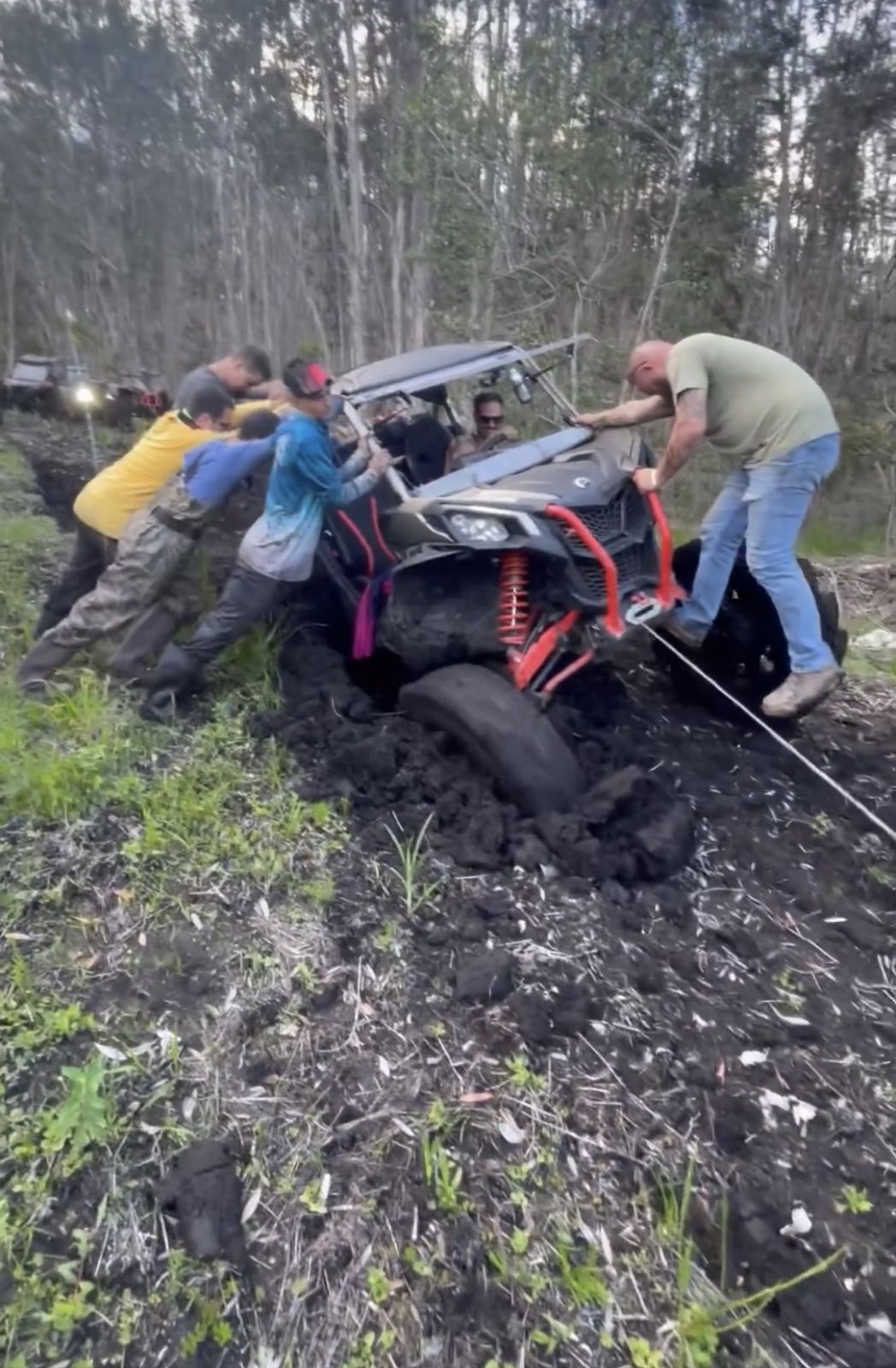 Group of riders recovering a SXS stuck in the mud