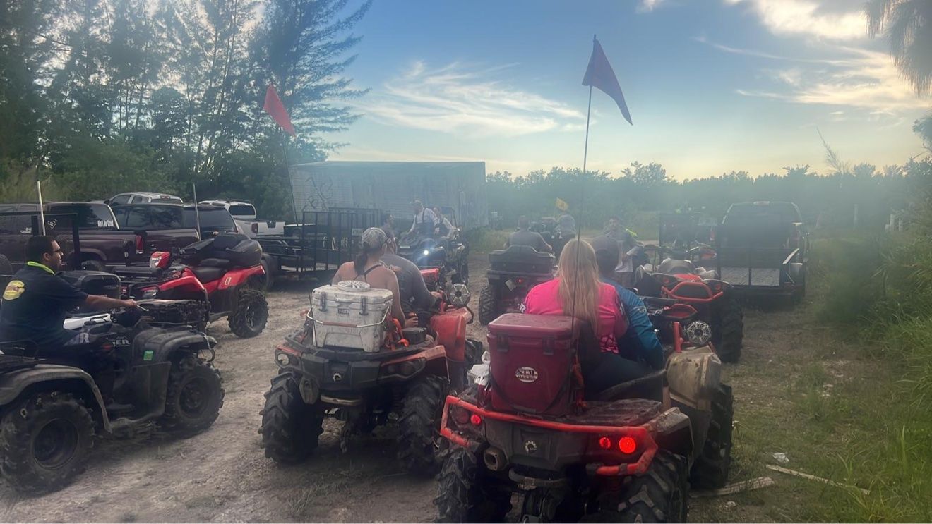 Convoy of ATVs at a dusty staging area