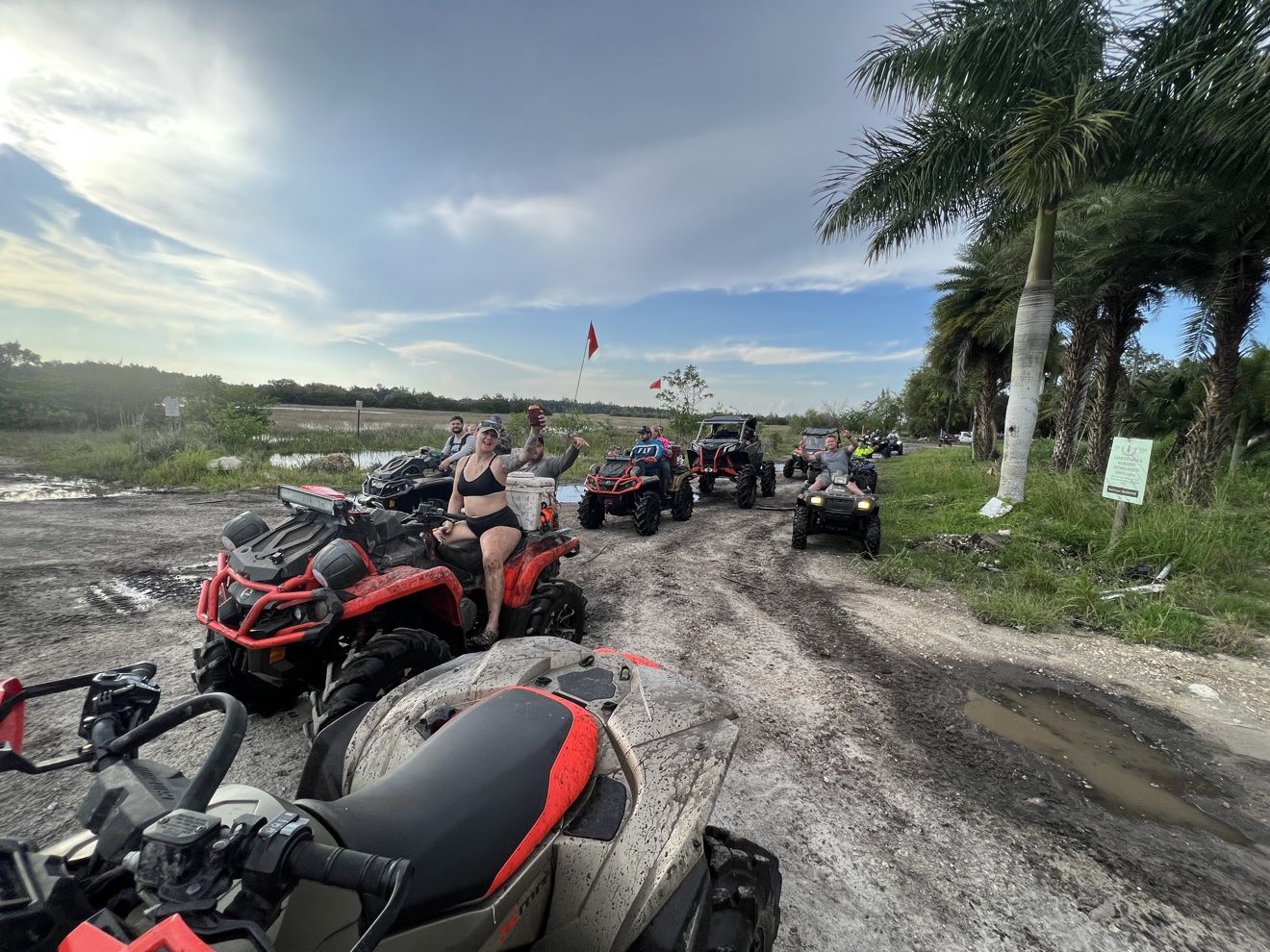 Lineup of muddy ATVs at a staging area