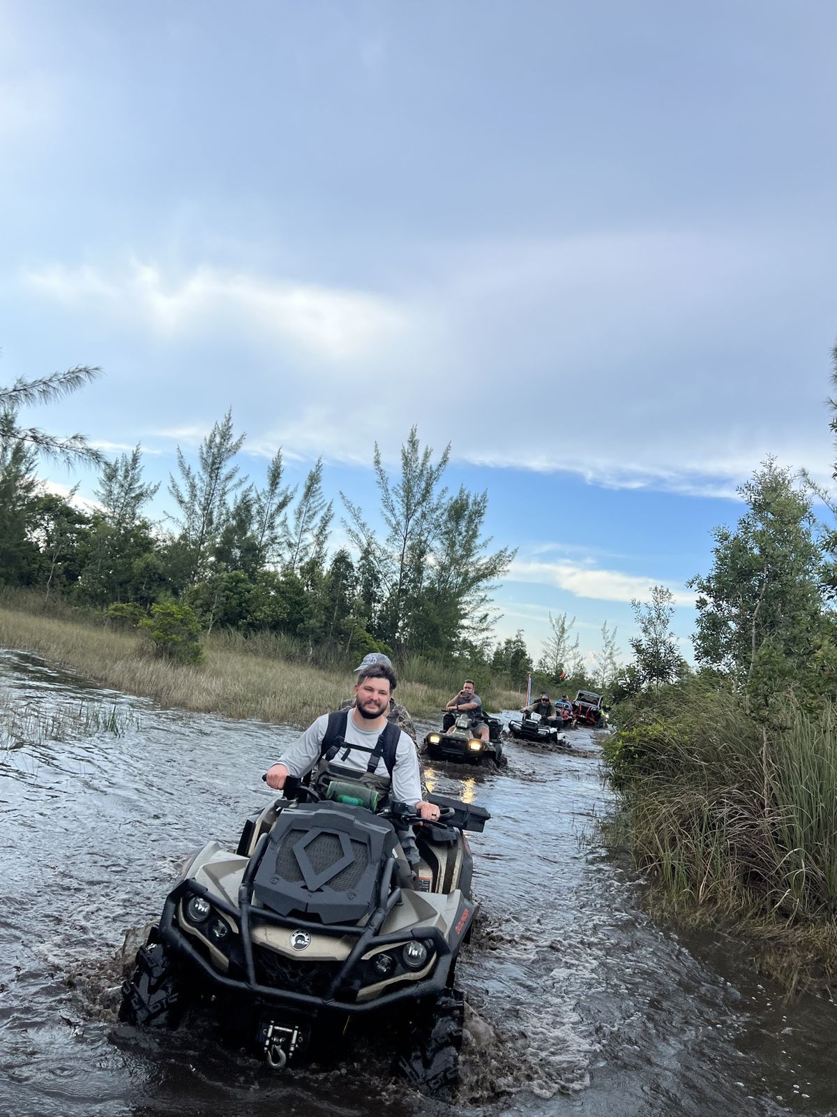 Convoy of ATVs in a water trail