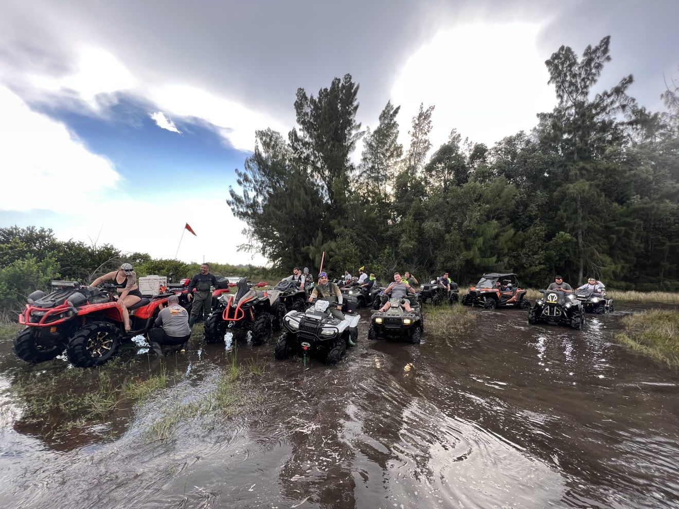 ATVs in a wide water crossing at sunset